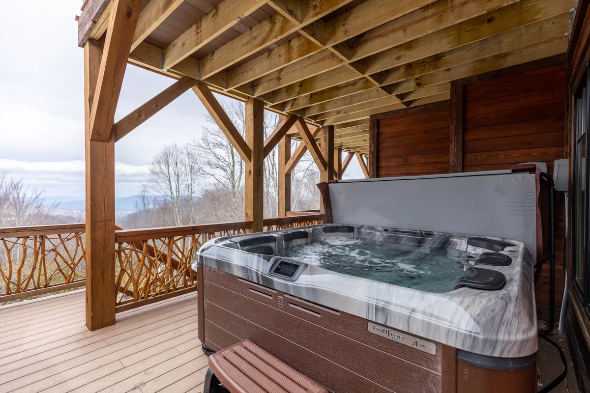 A peaceful outdoor hot tub framed by sturdy wooden beams, with a beautiful mountain view in the distance. The image exudes relaxation and togetherness in a setting ideal for evening unwinding or socializing beneath the stars.